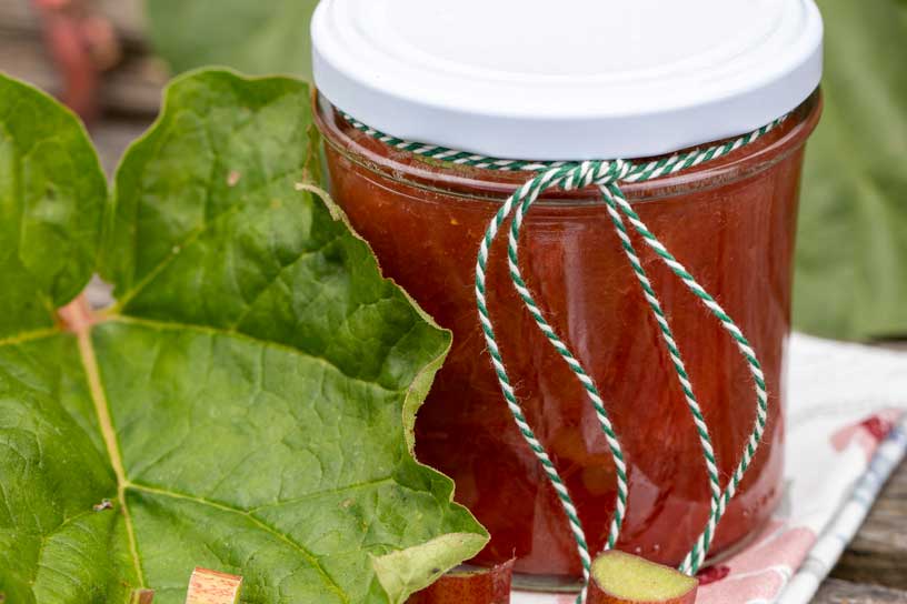 Rabarber-aardbeienjam in een potje met een touwtje eromheen